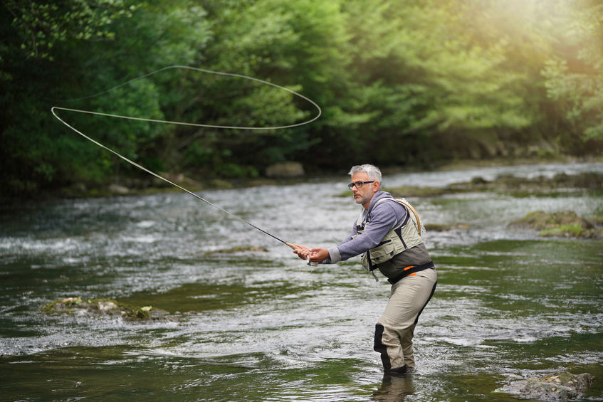 Fisherman fly-fishing in river